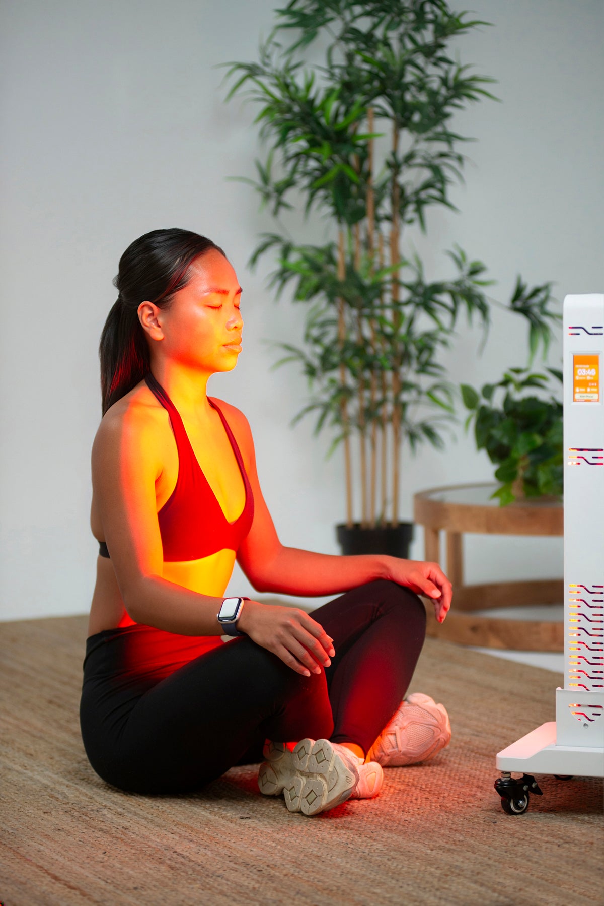Woman seated beside the Ultra Pro 200 red light panel