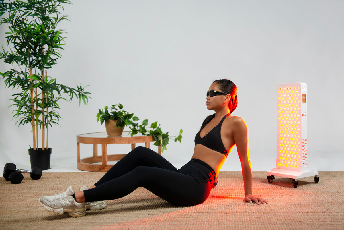 Woman relaxing on a mat beside the Ultra Pro 200 red light panel
